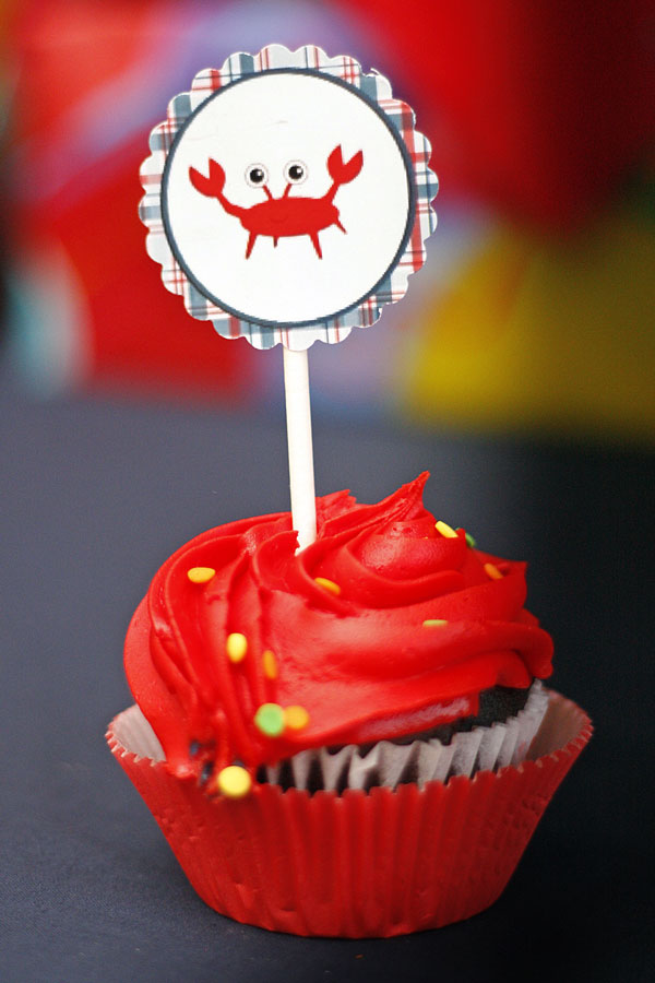 cupcake with red frosting and a crab cupcake topper